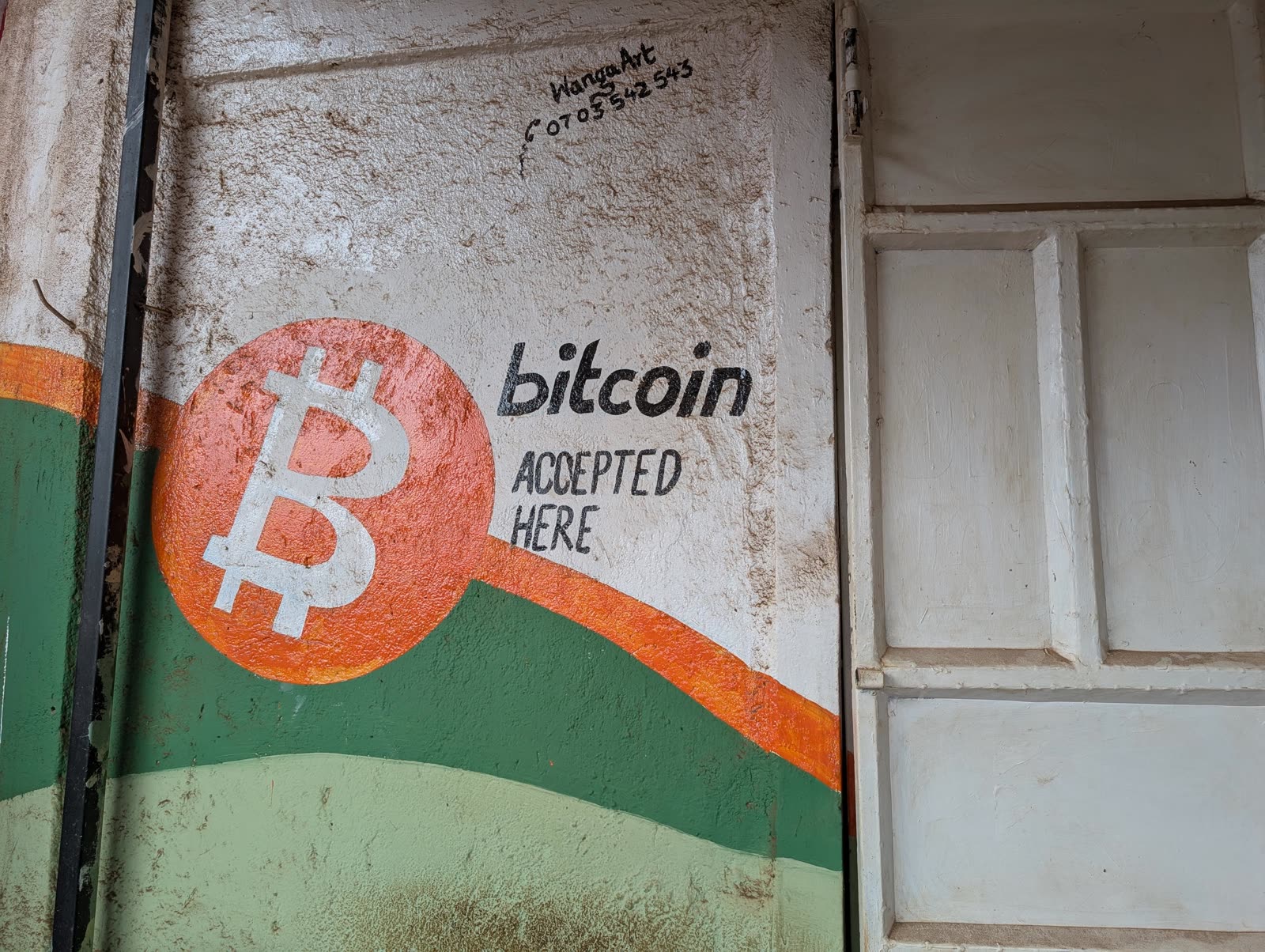 Hand-painted Bitcoin Accepted Here mural on a shop door in Matangi, Kenya